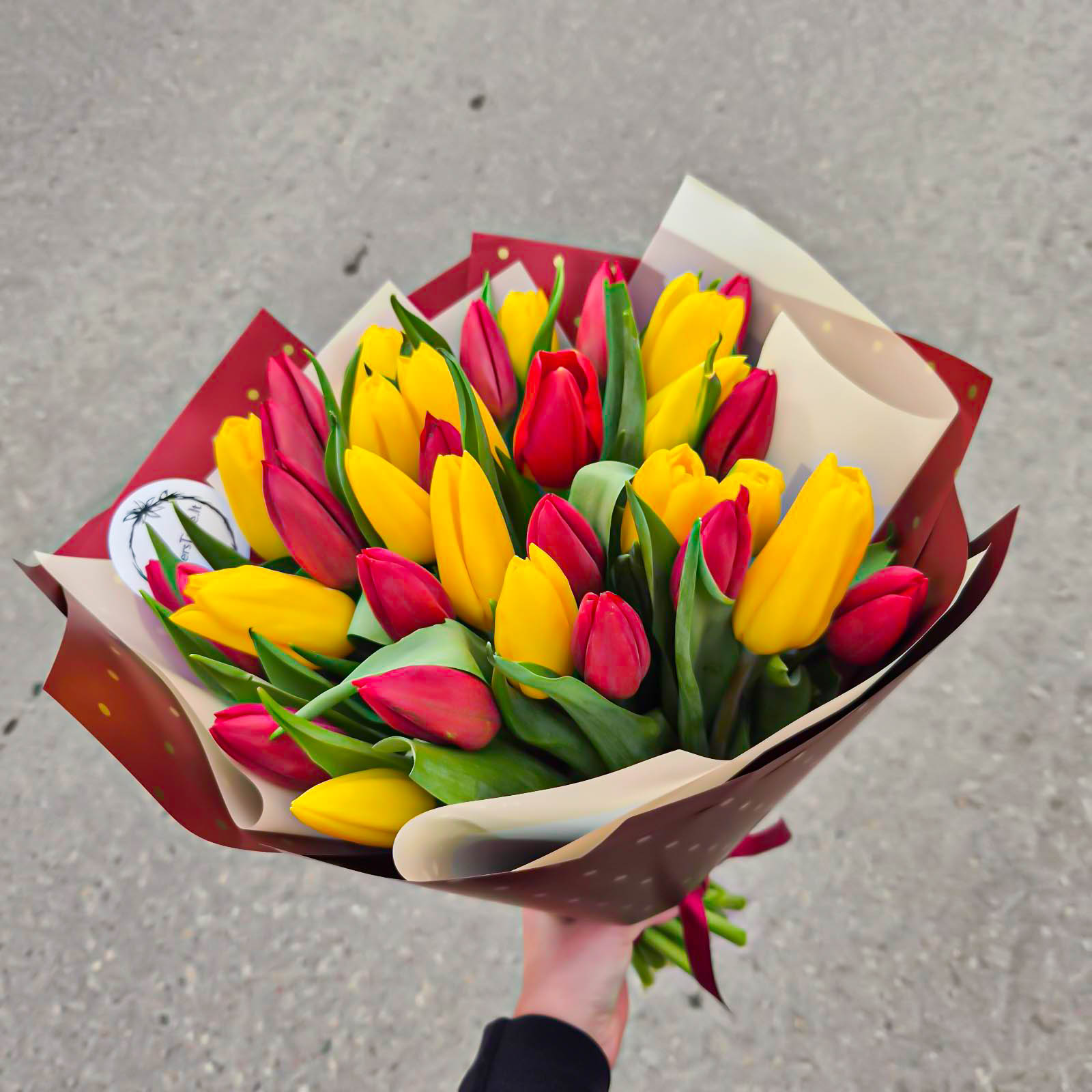 Raudonų ir geltonų tulpių puokštė merginai